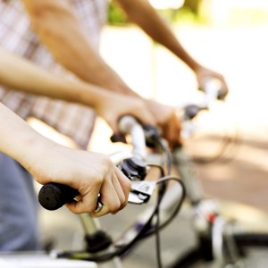 Two People Gripping Bicycle Handle Bars